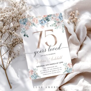May include: A floral-themed invitation card with a gold number 75 and the text "years loved". The invitation is for a celebration for Victoria and Archibald on Saturday, 20th March at 12pm at The Treehouse Inn. The address is 617 Olive Dr., Los Angeles, CA. Please RSVP by 1st March to Isabelle at 770-894-9012.