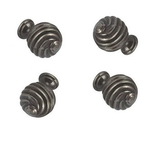 May include: Four antique silver cabinet knobs with a spiral design. The knobs are round and have a smooth, polished finish.