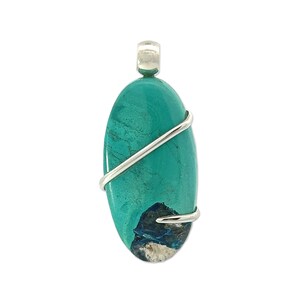 Puede incluir: Un colgante de piedra ovalada de color azul turquesa con un envoltorio de alambre plateado. La piedra preciosa tiene un patrón azul oscuro y blanco en la parte inferior.