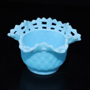 May include: A light blue glass bowl with a woven pattern and a scalloped edge.