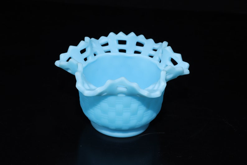 May include: A light blue glass bowl with a woven pattern and a scalloped edge.