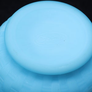 May include: A light blue glass bowl with a textured design. The bowl has a smooth, rounded bottom.