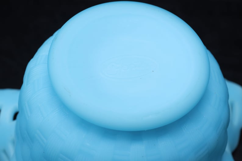 May include: A light blue glass bowl with a textured design. The bowl has a smooth, rounded bottom.