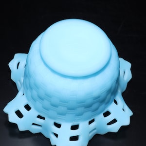 May include: A light blue glass bowl with a woven pattern and a scalloped edge.