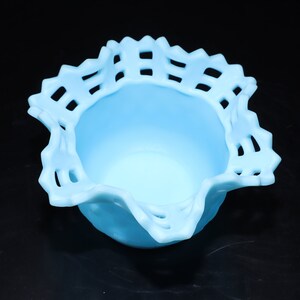 May include: A light blue glass bowl with a scalloped edge and a lattice design. The bowl is ideal for serving snacks or desserts.