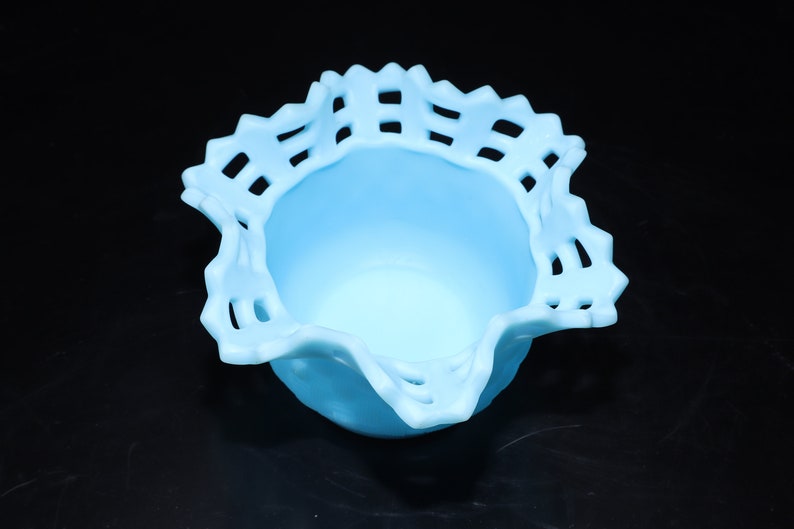 May include: A light blue glass bowl with a scalloped edge and a lattice design. The bowl is ideal for serving snacks or desserts.