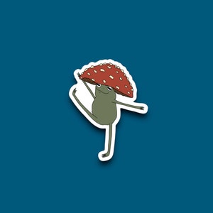 May include: A green frog wearing a red and white mushroom hat is dancing with one leg raised. The frog is outlined in white.