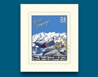 May include: A postage stamp featuring a mountain landscape with the text "Mount Timpanogos" in script. The stamp has a blue background with white snow-capped mountains and a town at the base. The stamp is cream-colored with a scalloped edge.