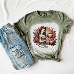 Hot Girl Fall Bleached T-Shirt | Pin-Up Girl Graphic Design with Pumpkins | Autumn Leaves & White Splatter Effect | Fall Season Shirt