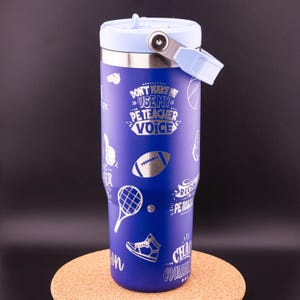 May include: A blue stainless steel tumbler with a light blue lid and handle. The tumbler has a silver design with various sports-related icons and the text "Don't make me use my PE teacher voice".
