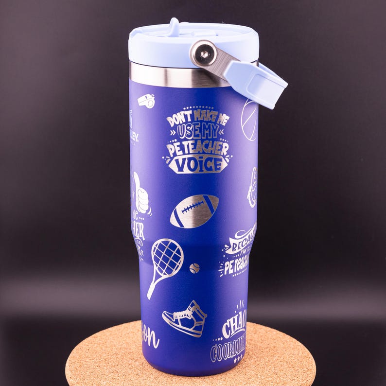 May include: A blue stainless steel tumbler with a light blue lid and handle. The tumbler has a silver design with various sports-related icons and the text "Don't make me use my PE teacher voice".