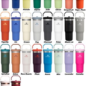 May include: A collection of 20 Stanley brand insulated tumblers in various colors, including lilac, lapis, pomelo, alpine, jade, citron, grapefruit, tiger plum, tigerlily, iris, cream, fog, charcoal, polar, black 2.0, ash, spirulina, ochre, rose quartz, plum, azure, mist, lavender, camellia, gold sugar, and gold pomeg.