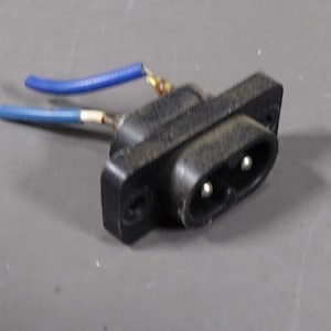 May include: A black electrical plug with two prongs and two blue wires attached.