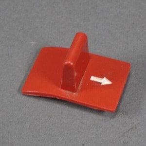May include: Red plastic switch with a white arrow pointing to the right. The switch has a raised handle.
