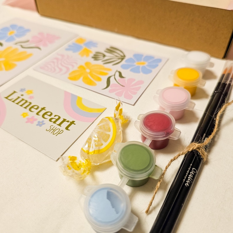 May include: A craft kit with paint pots in various colors, paintbrushes, and floral design cards. The kit includes a candy and a card with the text "Limeteart SHOP". The paint colors include white, yellow, pink, red, green, and blue.