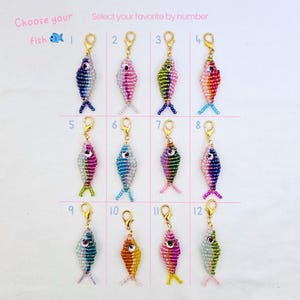 May include: A collection of beaded fish charms in various colors, each with a gold-colored clasp. The image includes text that says "Choose your fish" and "Select your favorite by number". Each fish is numbered 1 through 12.