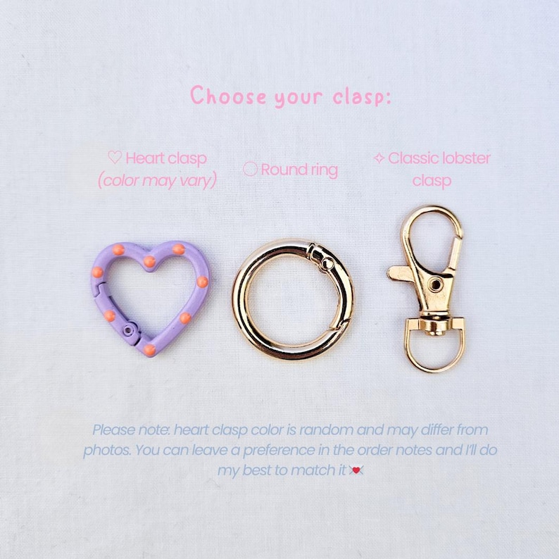 May include: Image of three clasp options: a heart-shaped clasp in lavender with orange dots, a gold round ring clasp, and a gold classic lobster clasp. Text reads "Choose your clasp:" and additional text about color variations.