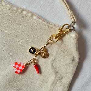 llavero dorado de charms con corazón, estrella, sol y pimiento