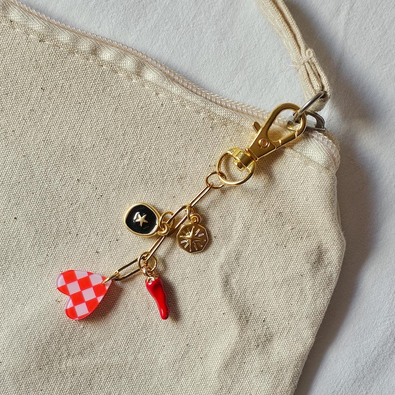 llavero dorado de charms con corazón, estrella, sol y pimiento