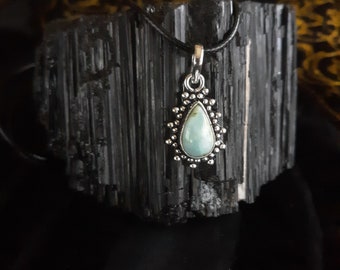 May include: A silver pendant necklace with a teardrop-shaped turquoise stone set in a silver bezel. The pendant is surrounded by a silver filigree design.