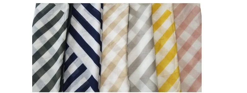 Puede incluir: Una colecci&oacute;n de seis art&iacute;culos de tela doblados, cada uno con un color y patr&oacute;n distintos. Los patrones son rayas diagonales en un dise&ntilde;o a cuadros. Los colores incluyen tonos de verde, azul marino, beige, gris, amarillo y rosa, todos sobre un fondo blanco.