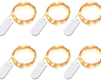 May include: Set of six copper wire string lights with warm white LED bulbs. Each strand has a battery pack and is approximately 6.5 feet long.