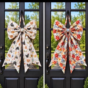 May include: Two large fabric bows hanging on black doors. The left bow features a cream background with a repeating pattern of colorful chickens. The right bow displays a vibrant floral print with red, orange, and blue flowers on a light background.