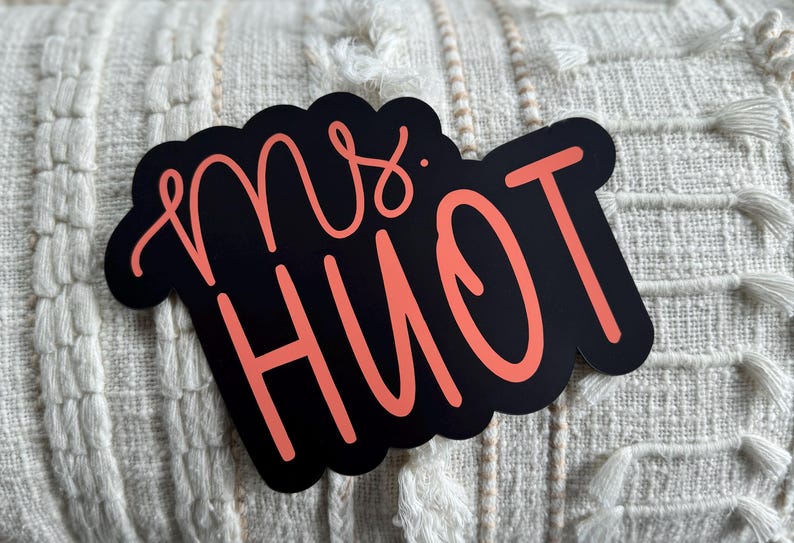Puede incluir: Un letrero en blanco y negro con el texto "Mrs. Hiott" en rosa.