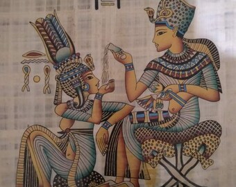 May include: A hand-painted papyrus scroll depicting an Egyptian pharaoh and queen in a scene of offering. The pharaoh is seated on a throne and the queen is kneeling before him. The scroll is decorated with hieroglyphs and other Egyptian motifs.