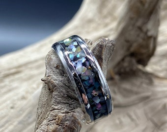 May include: A silver ring with a band of iridescent blue and purple abalone shell inlay.