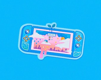 Puede incluir: Una pegatina de consola de juegos Nintendo Switch azul y rosa con un paisaje de ensueño en la pantalla. La pantalla dice "DREAM?" y presenta un cielo rosa con nubes, un sol amarillo y una planta verde que crece desde la parte superior de la consola.