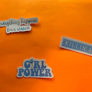 Puede incluir: Tres pegatinas con texto sobre un fondo naranja. Una pegatina dice "everything happens for a reason", otra dice "KILLIN' IT", y la tercera dice "GIRL POWER" con un dise&ntilde;o floral. Las pegatinas tienen una combinaci&oacute;n de colores azul y blanco.
