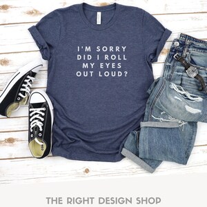 May include: A navy blue t-shirt with white text that reads "I'm sorry did I roll my eyes out loud?"