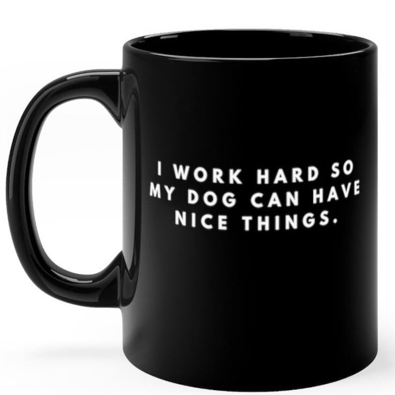 May include: Black coffee mug with white text that reads "I work hard so my dog can have nice things."