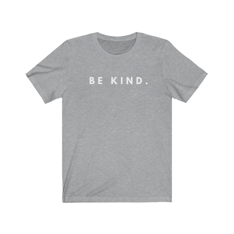 Puede incluir: Una camiseta gris jaspeada con el texto "BE KIND." impreso en blanco en la parte delantera.