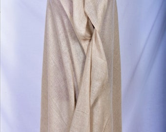 May include: A beige pashmina shawl made of soft, luxurious cashmere. The shawl is draped over a mannequin and is folded in a way that shows the texture of the fabric.