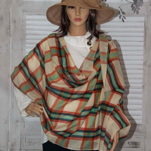 May include: A beige, red, teal, and black plaid scarf with a brown hat.