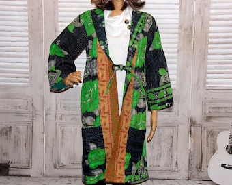 May include: A long, black and green quilted jacket with floral patterns. The jacket has a tie closure at the waist and pockets on the sides.