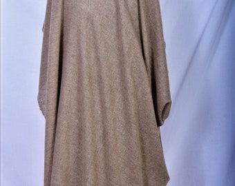 May include: A beige poncho made from a soft, woven material. The poncho features a draped design with sleeves and a rounded neckline. The fabric has a subtle texture, and the style is casual and comfortable. The garment is suitable for cooler weather.