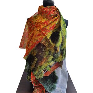 May include: A colorful scarf with a vibrant abstract design in shades of red, yellow, green, and black. The scarf is draped over a black mannequin, showcasing its flowing fabric and fringed edges. The scarf's pattern resembles a landscape.