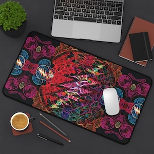 May include: A black rectangular mouse pad with a vibrant, psychedelic design in red, pink, blue, and yellow. The design features a central, swirling pattern surrounded by repeating circular motifs. A white computer mouse rests on the pad.