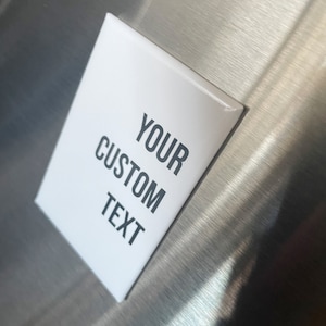 May include: White rectangular magnet with black text that reads "YOUR CUSTOM TEXT".