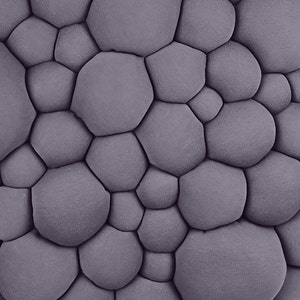 May include: A close-up of a textured, gray fabric with a pattern of rounded, irregular shapes. The shapes are tightly packed together, creating a bubbly, three-dimensional effect. The fabric has a soft, matte appearance.