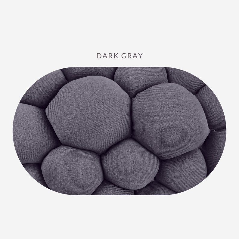 May include: Close-up of a dark gray, textured fabric with a bubble-like pattern. The fabric is a solid color, and the text "DARK GRAY" is displayed above the fabric.