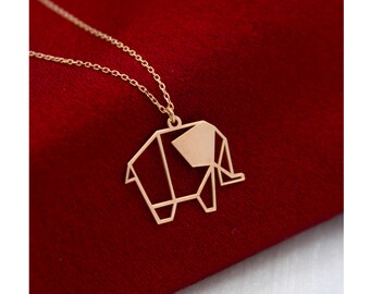 May include: A gold necklace with a geometric origami elephant pendant. The pendant is made of thin metal and has a delicate, intricate design.