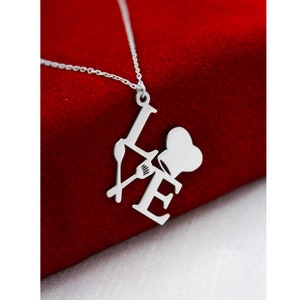 May include: Silver necklace with a pendant that says "LOVE" with a chef's hat and a fork and spoon in the letters.
