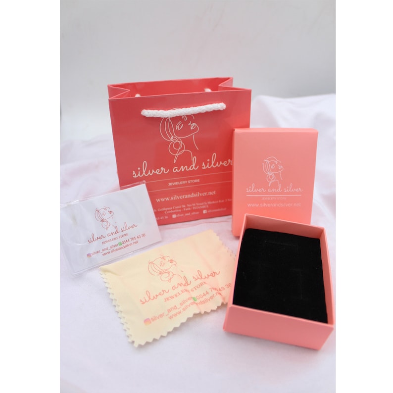May include: A pink gift bag with a white handle and the text "silver and silver jewelry store www.silverandsilver.net" printed on the front. A pink jewelry box with the same text is also shown. The box is open and has a black velvet interior.