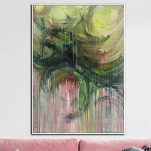 May include: Abstract painting with a vertical orientation. The artwork features swirling green, yellow, and pink hues, creating a dynamic and textured composition. The painting is framed and hangs above a pink sofa.