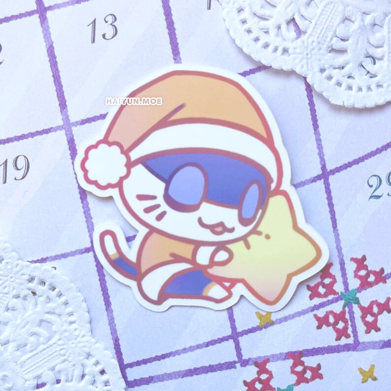 May include: A white cartoon cat wearing a red and orange Santa hat and holding a yellow star. The cat has blue eyes and a pink nose. The text "HAI YUN.MOE" is visible on the image.
