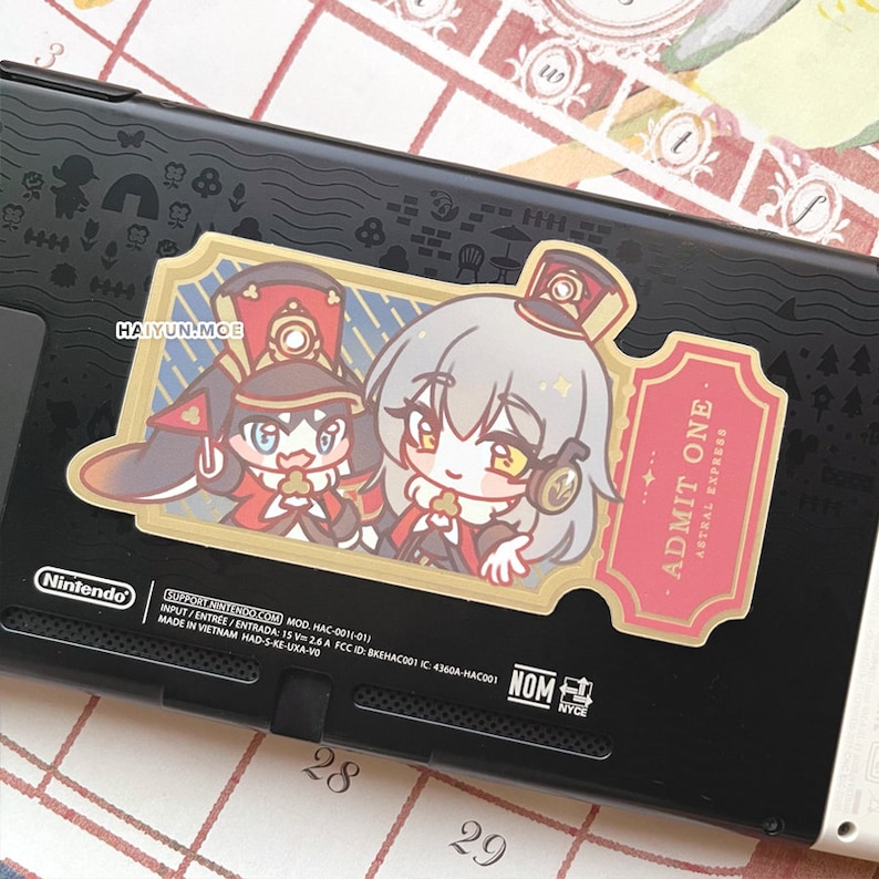 May include: A sticker featuring two anime characters in military uniforms. The characters are standing in front of a gold ticket with the text "ADMIT ONE ASTRAL EXPRESS".